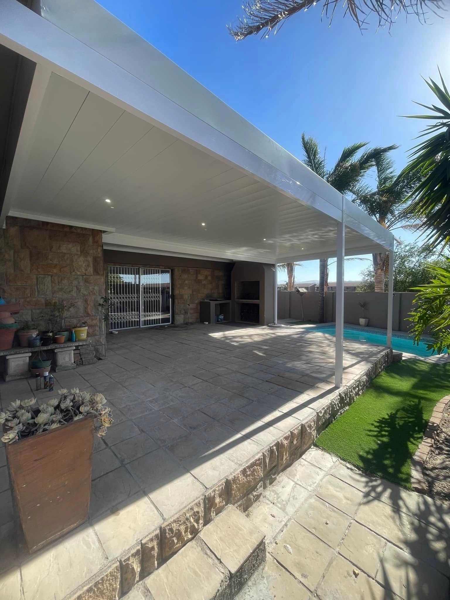 White aluminium ceiling panels under a patio cover beside a pool