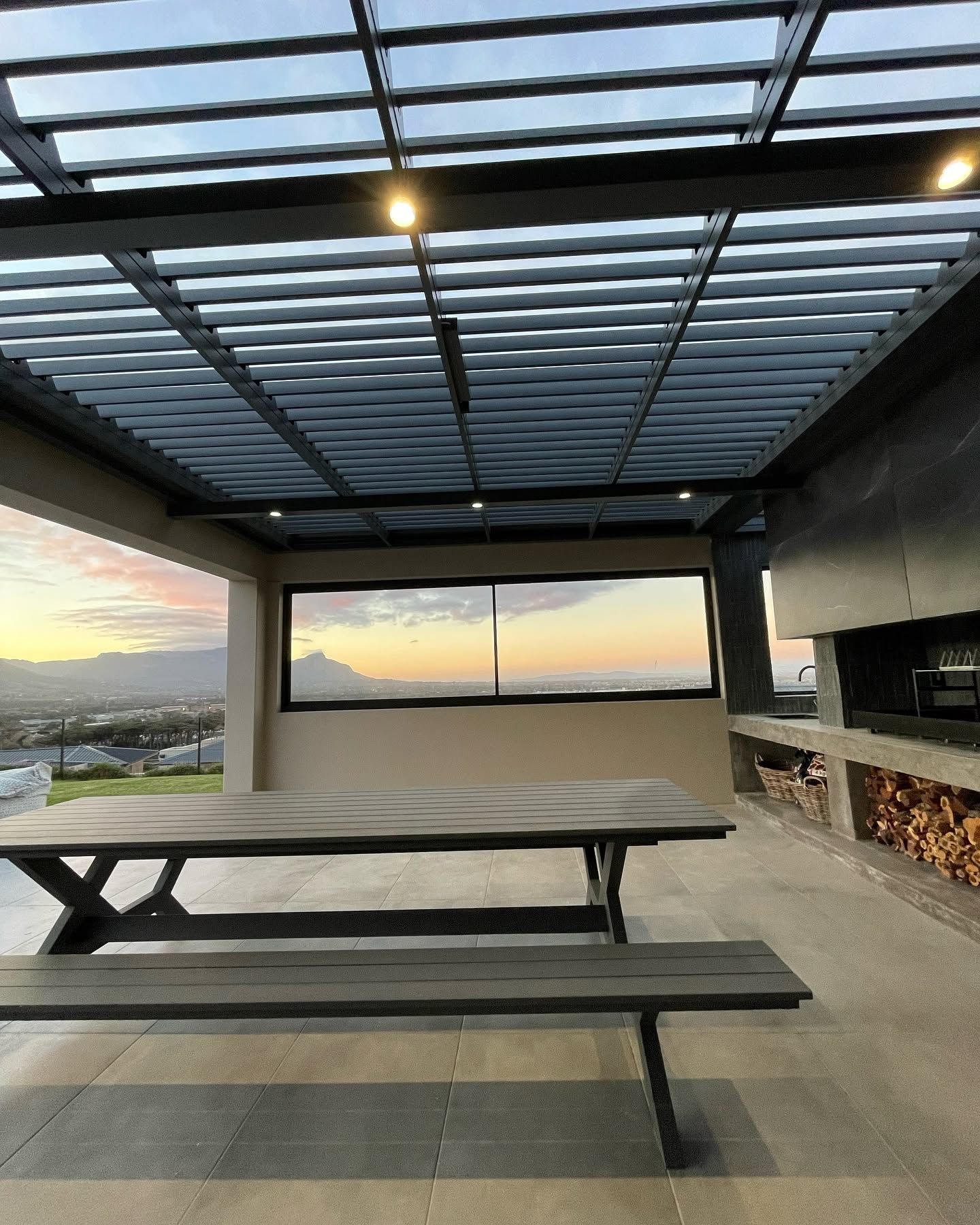 Louvre roof over a covered braai area with mountain views at sunset