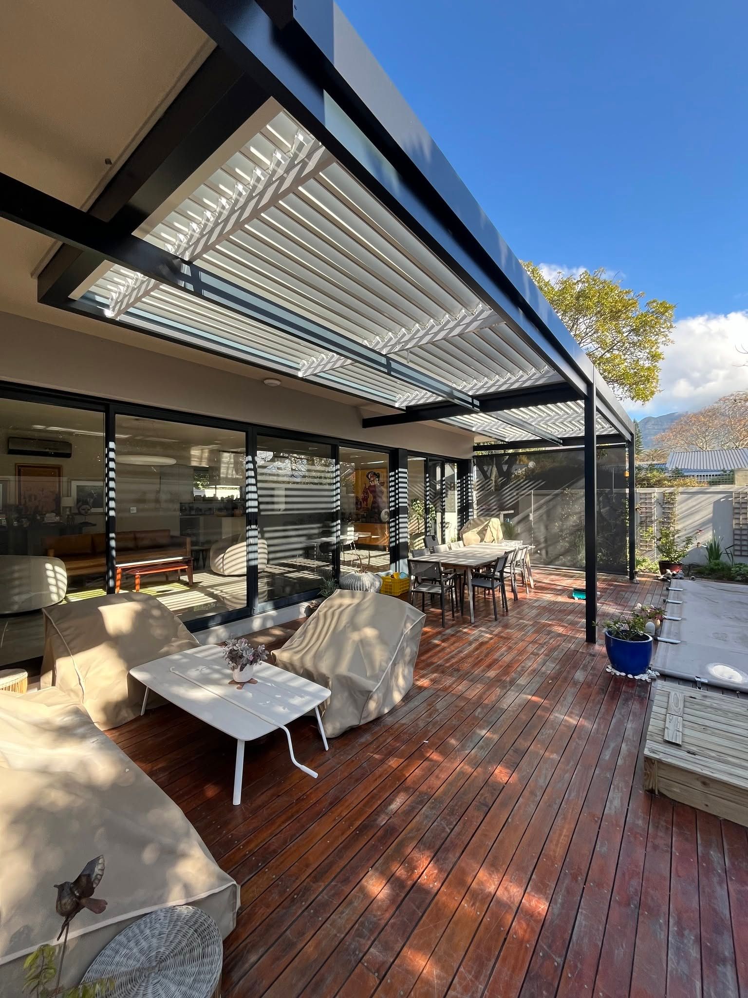 Charcoal louvre awning with white louvres over a timber deck
